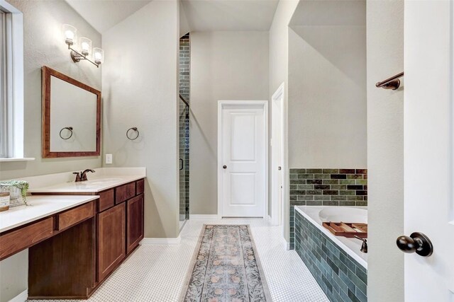 bathroom with vanity, tile patterned floors, and tiled bath