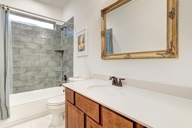 full bathroom featuring tiled shower / bath, vanity, and toilet