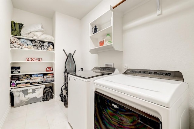 clothes washing area with light tile patterned floors and washer and dryer