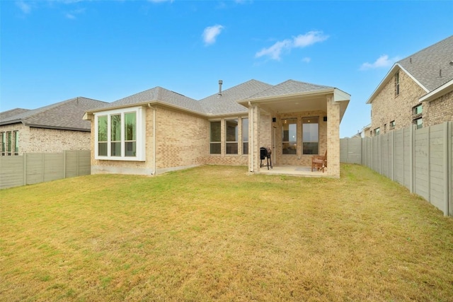 back of house featuring a patio area and a lawn