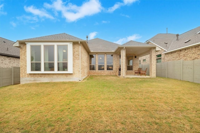 rear view of property with a patio area and a lawn