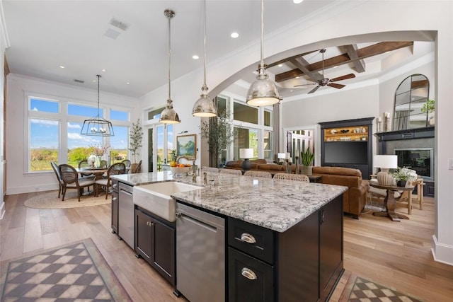 kitchen with coffered ceiling, a center island with sink, ceiling fan with notable chandelier, stainless steel dishwasher, and beam ceiling