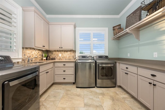 laundry area featuring washer and dryer, crown molding, and sink