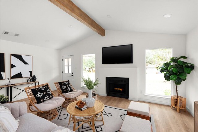 living room with vaulted ceiling with beams and light hardwood / wood-style floors