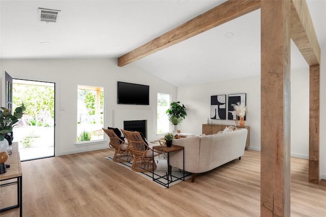 living room featuring vaulted ceiling with beams, a wealth of natural light, and light wood-type flooring