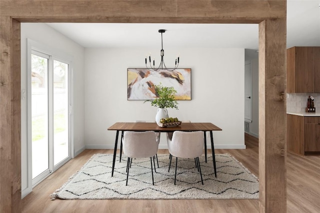 dining space featuring light hardwood / wood-style flooring and an inviting chandelier