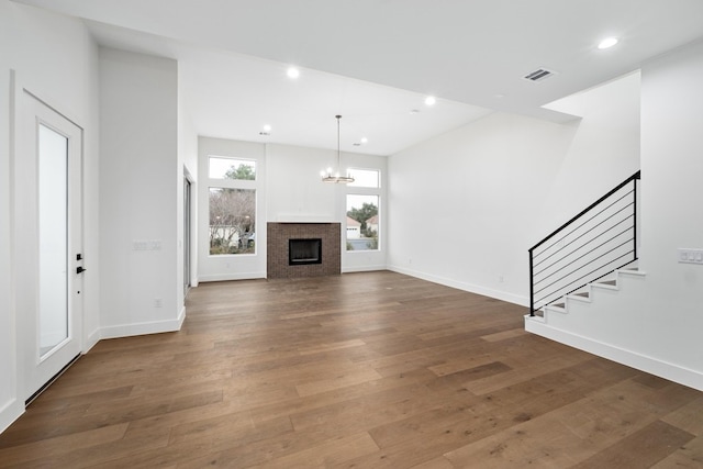 unfurnished living room featuring a chandelier and dark hardwood / wood-style floors