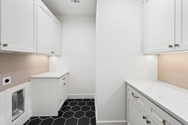 laundry room featuring hookup for an electric dryer and cabinets