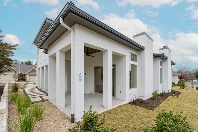 back of property with a patio area, a garage, and a lawn