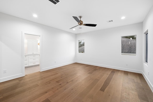 unfurnished bedroom with ceiling fan, connected bathroom, and hardwood / wood-style floors