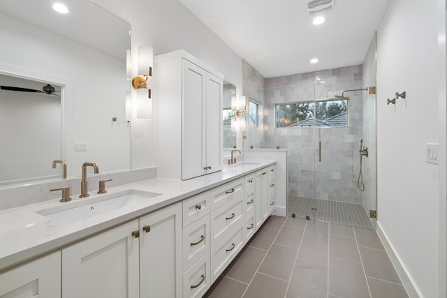 bathroom featuring a shower with shower door, vanity, and tile patterned floors