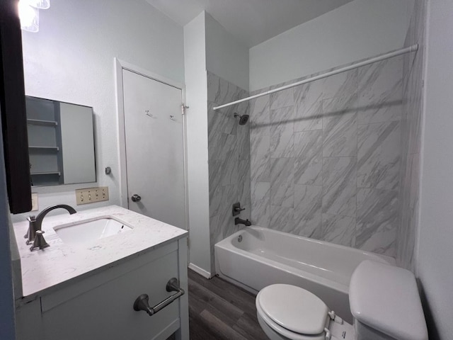 full bathroom featuring hardwood / wood-style flooring, vanity, tiled shower / bath combo, and toilet