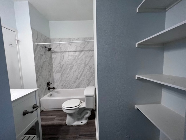 full bathroom featuring vanity, wood-type flooring, tiled shower / bath combo, and toilet