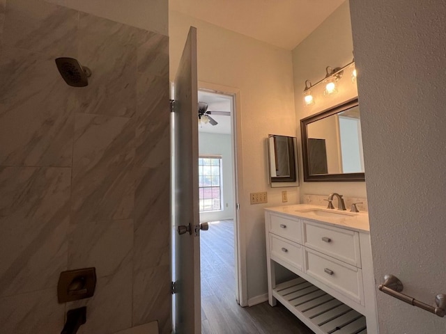 bathroom with hardwood / wood-style floors, vanity, ceiling fan, and walk in shower