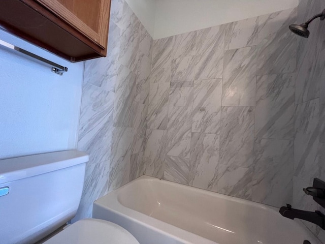 bathroom featuring tiled shower / bath combo and toilet