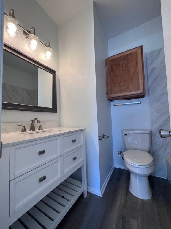 bathroom with hardwood / wood-style floors, vanity, and toilet