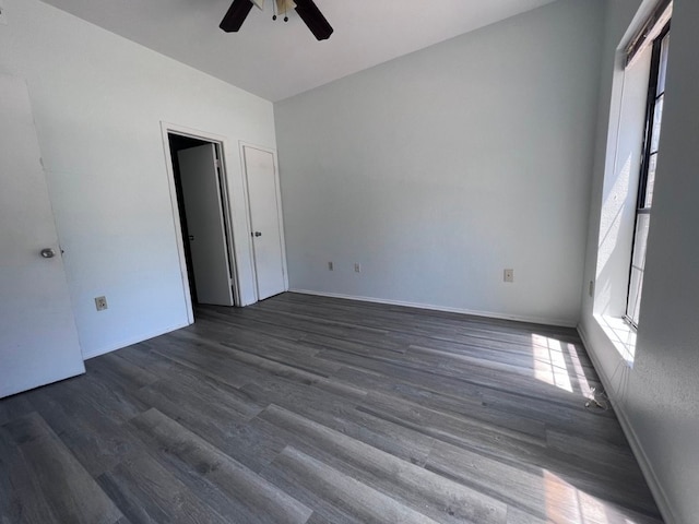 unfurnished bedroom featuring ceiling fan and dark hardwood / wood-style floors