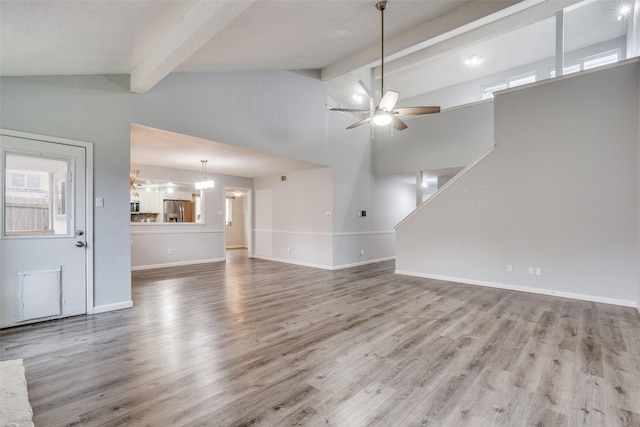 unfurnished living room featuring ceiling fan, beamed ceiling, high vaulted ceiling, and wood-type flooring