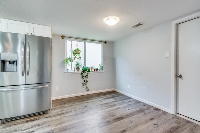 kitchen featuring light hardwood / wood-style flooring, white cabinetry, a textured ceiling, and stainless steel refrigerator with ice dispenser