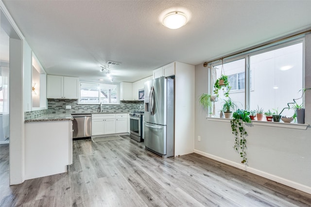 kitchen featuring sink, white cabinetry, appliances with stainless steel finishes, and tasteful backsplash