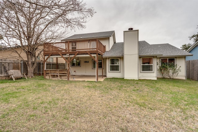 back of property featuring a patio, a wooden deck, and a yard