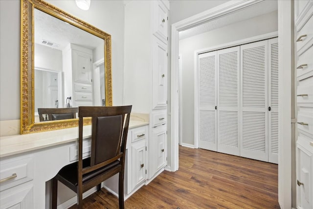 office area with dark hardwood / wood-style flooring and built in desk