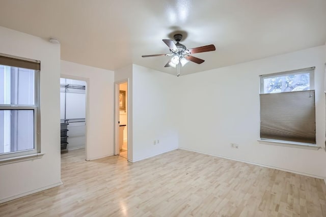 unfurnished room with light wood-style floors and a ceiling fan