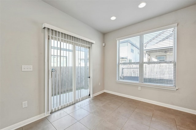 spare room featuring recessed lighting, tile patterned flooring, a wealth of natural light, and baseboards