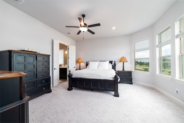 bedroom with ensuite bathroom, ceiling fan, and light carpet