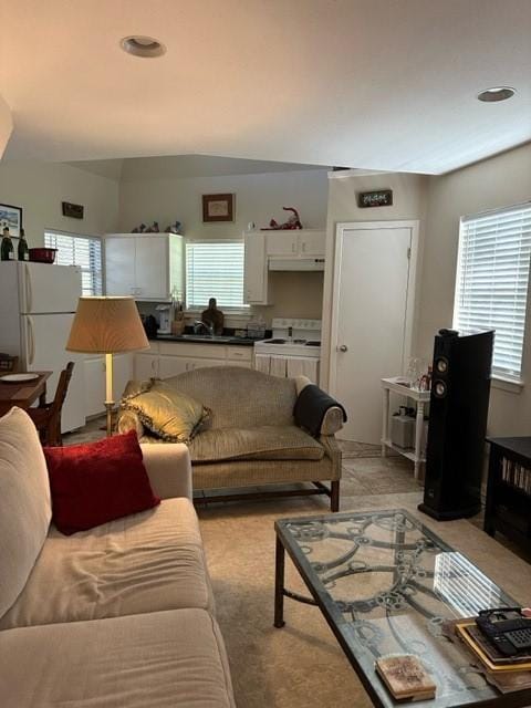 living room featuring plenty of natural light, light colored carpet, and sink