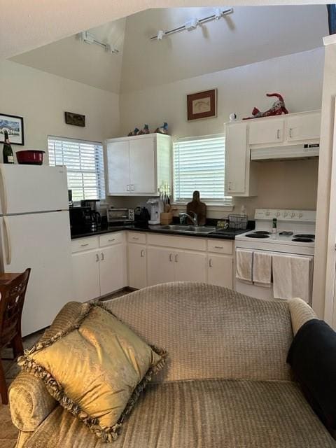 kitchen with white cabinetry, white appliances, sink, and vaulted ceiling