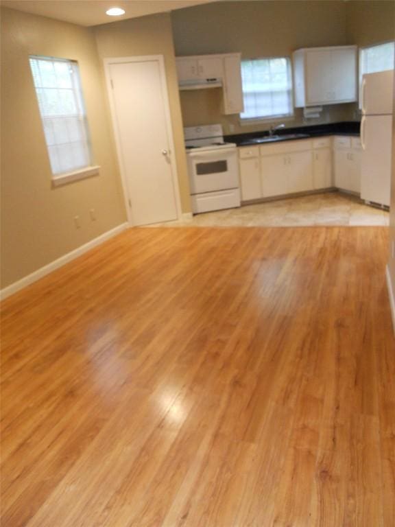 kitchen featuring white appliances, white cabinetry, a healthy amount of sunlight, and sink