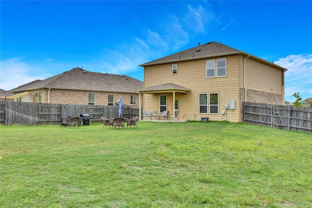 back of house with a patio area and a lawn