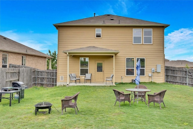 rear view of property with a patio, a fire pit, and a lawn