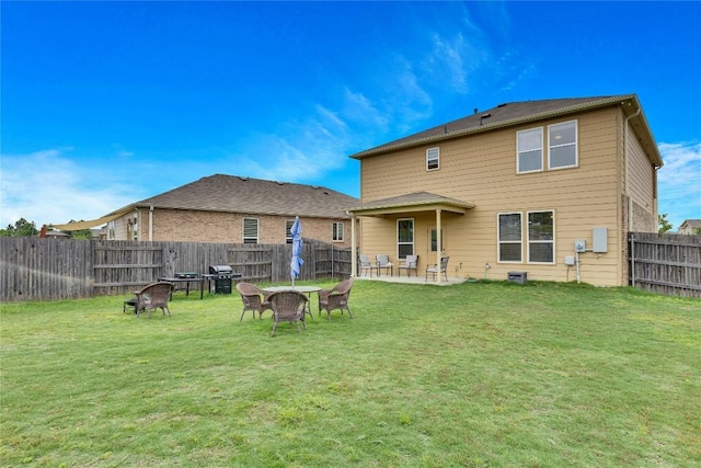 rear view of property with a yard and a patio