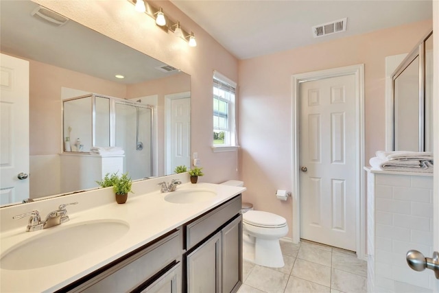 bathroom featuring tile patterned floors, vanity, toilet, and walk in shower