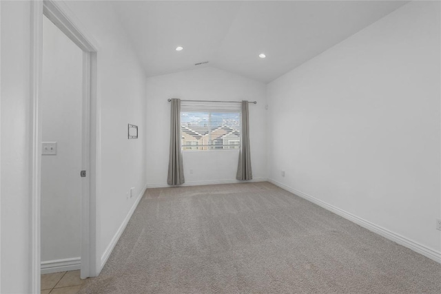 carpeted empty room with vaulted ceiling