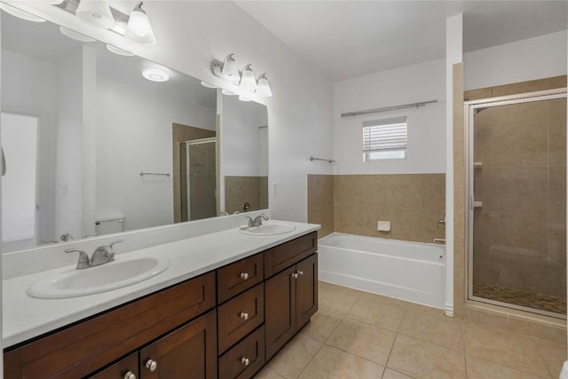 full bathroom with tile patterned flooring, shower with separate bathtub, vanity, and toilet