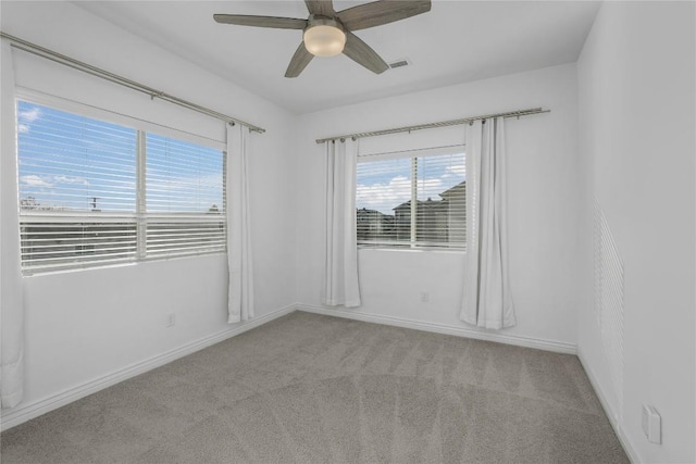 spare room with ceiling fan and light carpet