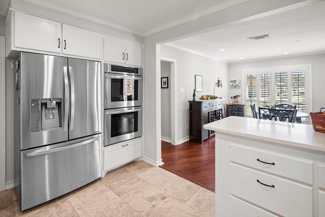 408 Silver Spur, Horseshoe Bay, TX 78657 - kitchen featuring stainless steel appliances, white cabinets, light countertops, crown molding, and recessed lighting