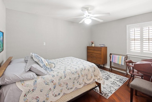 bedroom with dark hardwood / wood-style flooring and ceiling fan