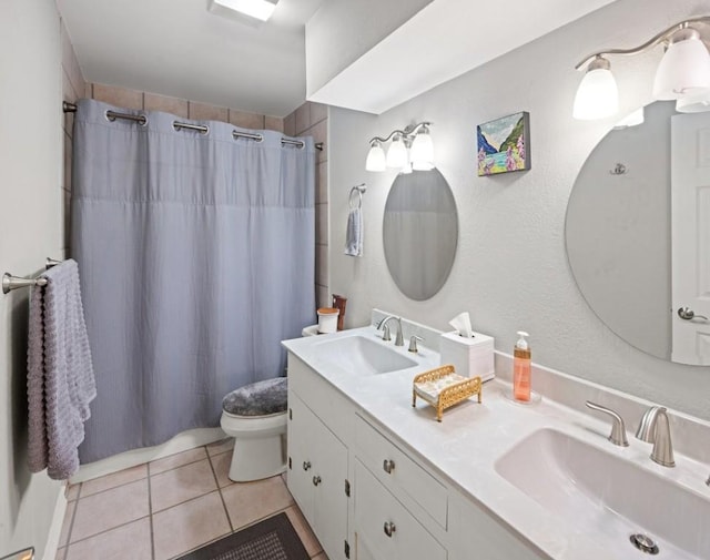 bathroom with toilet, vanity, tile patterned floors, and walk in shower