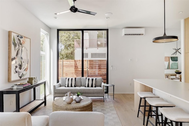 living room with light hardwood / wood-style floors, a wall unit AC, a wall of windows, and ceiling fan