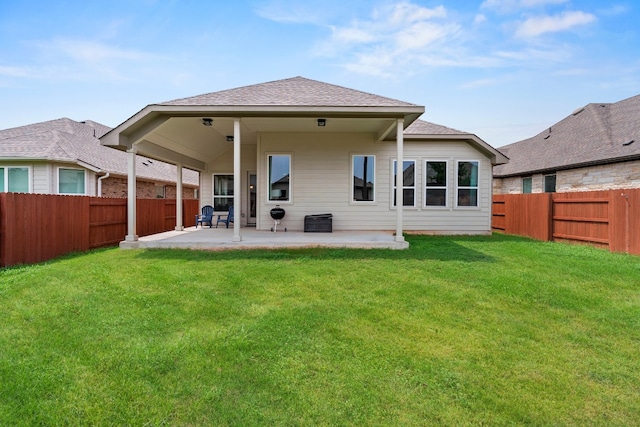 rear view of house with a patio and a lawn