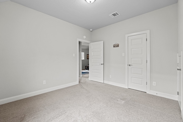 unfurnished bedroom with carpet flooring and a textured ceiling