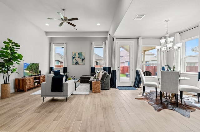 interior space featuring ceiling fan with notable chandelier and light wood-type flooring