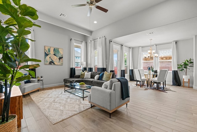 living room with light hardwood / wood-style flooring and ceiling fan with notable chandelier