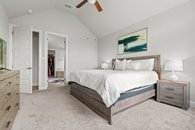 bedroom featuring ceiling fan, ensuite bathroom, lofted ceiling, and light carpet