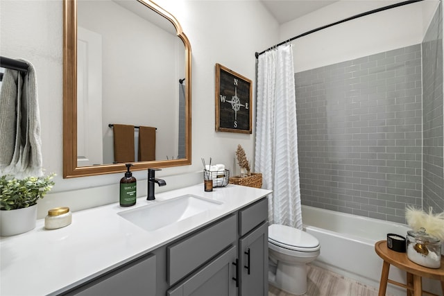 full bathroom featuring toilet, wood finished floors, shower / bath combo with shower curtain, and vanity