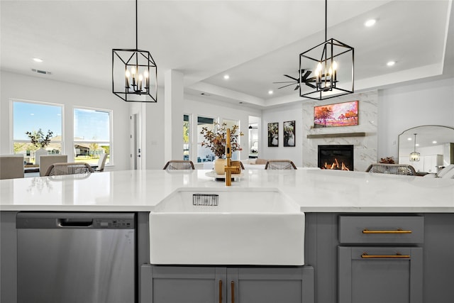 kitchen featuring gray cabinets, dishwasher, hanging light fixtures, and a raised ceiling